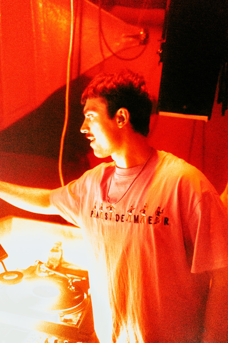 Adrian behind the decks under red light